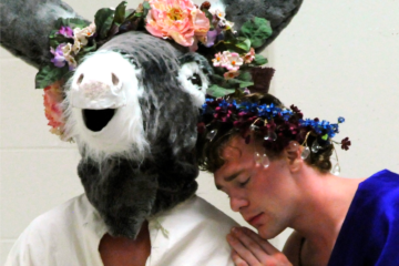 Actors perform A Midsummer Nights dream. Titania rests her head on a Donkey wearing a flower crown.