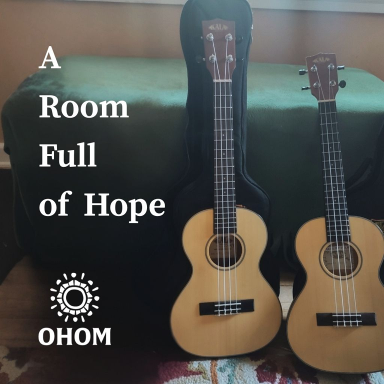 Two ukuleles leaning up against a chest.