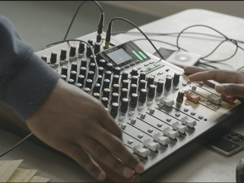 picture of two hands working a sound board